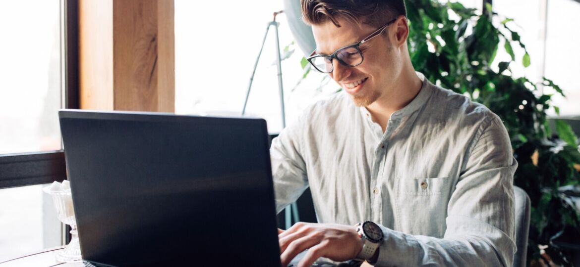 attractive-businessman-eyeglasses-working-laptop-typing-spending-time-cafe_1