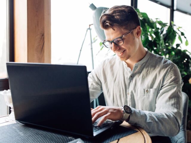 attractive-businessman-eyeglasses-working-laptop-typing-spending-time-cafe_1